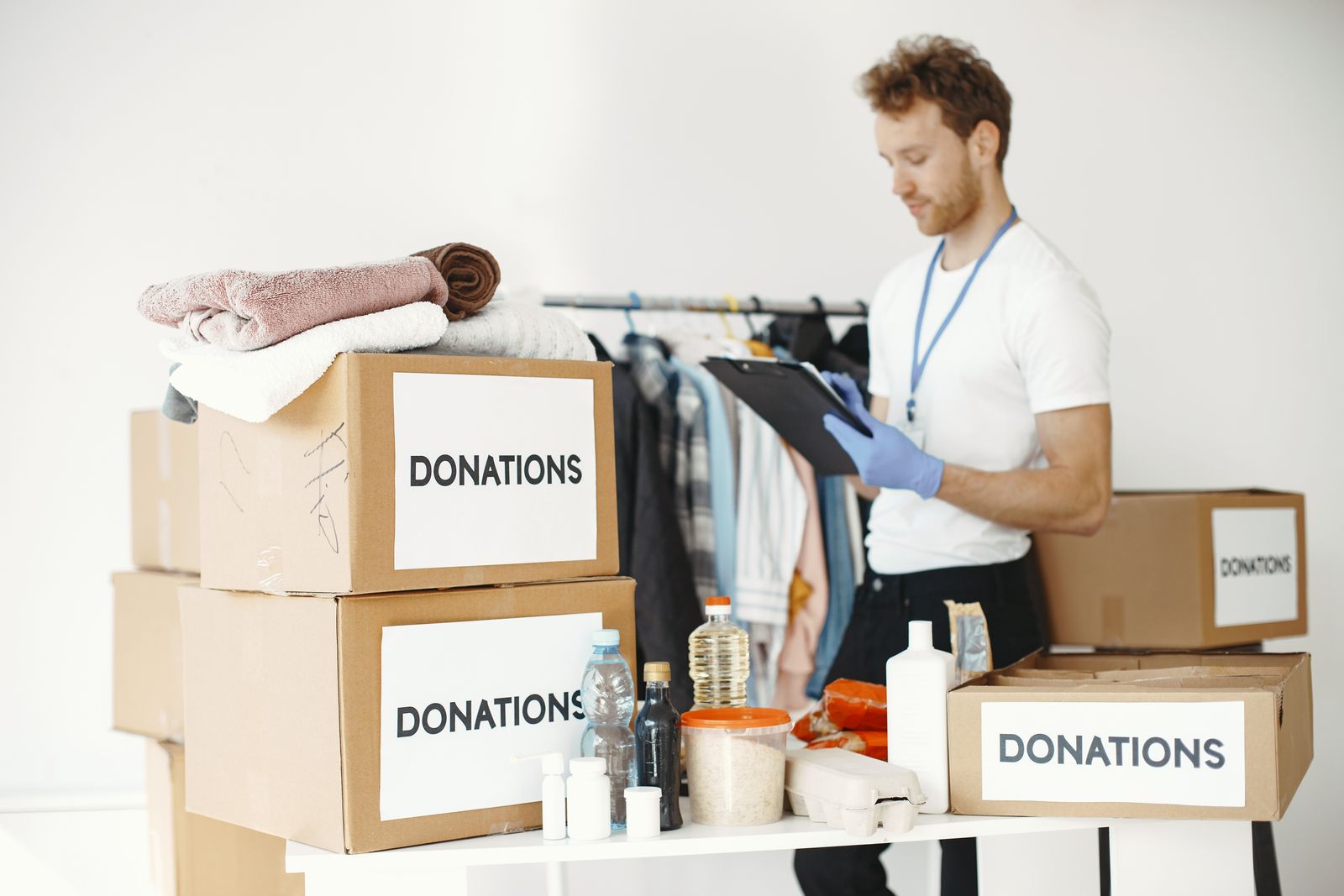 Volunteer organizing labeled donation boxes of clothing and supplies