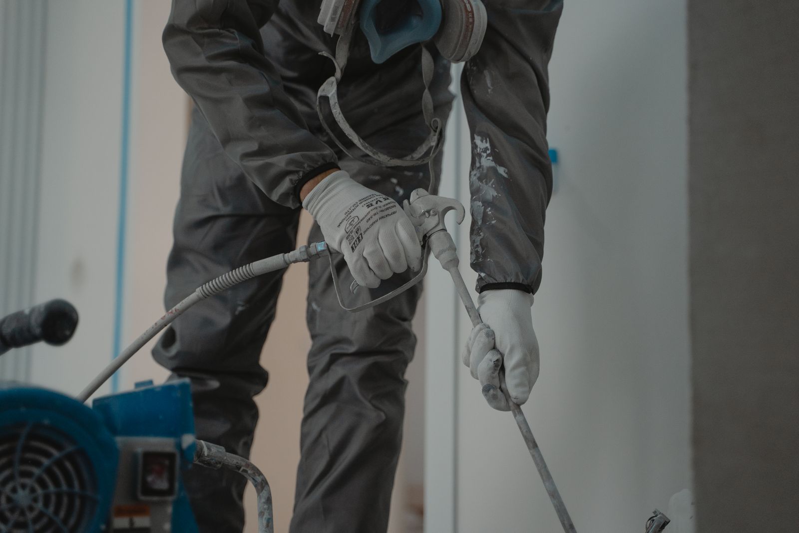 Worker installing spray foam insulation in a home
